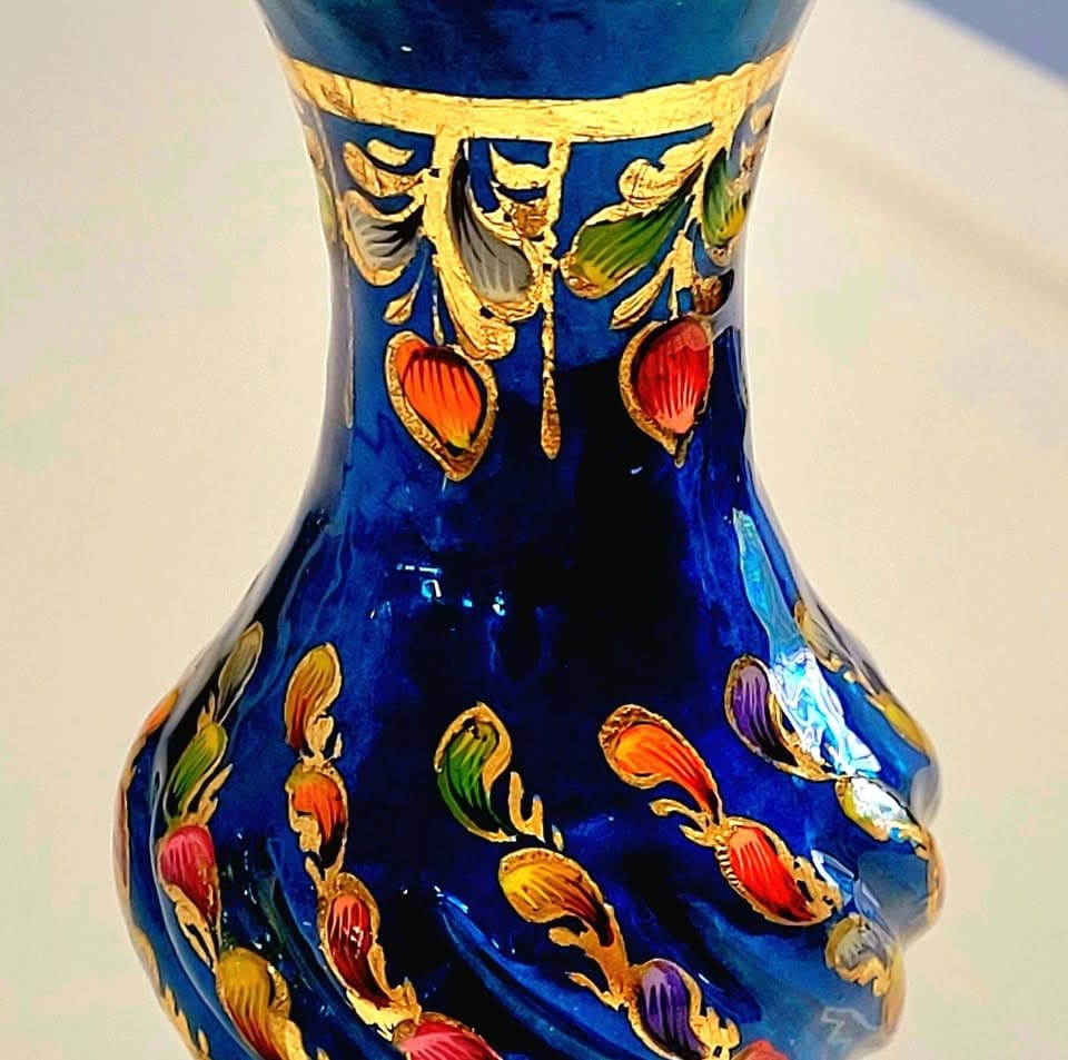 A cobalt-blue vase hand-painted with gold scrollwork and multicolored enamel blossoms